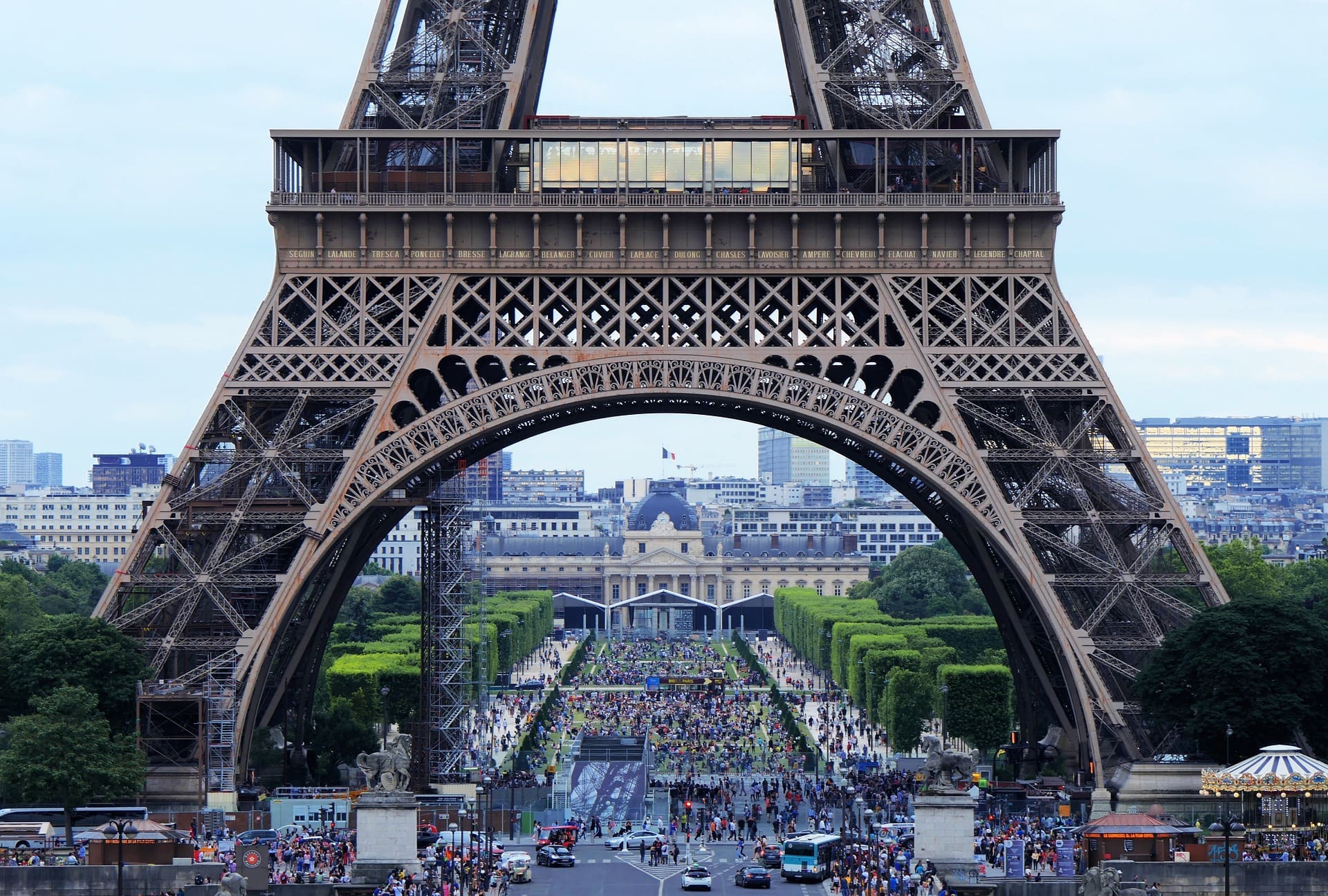 A picture of a street in Paris taken from under the Eiffel Tower.